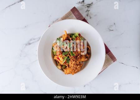 Indonesische Küche Salz und Chili Squid in einer Schale isoliert auf matter Draufsicht auf grauem Marmorboden Stockfoto