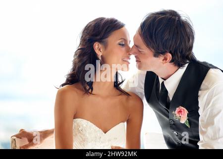 Wie verliebt wie Tag 1. Ein glückliches frisch verheiratetes Paar, das sich küsst. Stockfoto