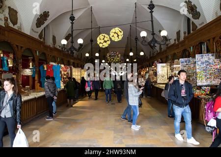 Eine Einkaufspassage in der Krakauer Altstadt, Polen, in der Touristen und Bewohner die zahlreichen Kaufartikel und Souvenirs erkunden. Stockfoto