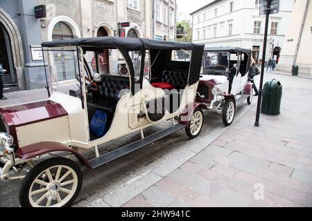 Zwei Retro Classic Autos in Krakau, Polen, stehen Touristen und Touristen zur Verfügung, um die Altstadt im historischen Stil zu erkunden Stockfoto