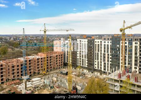 Bau eines neuen mehrstöckigen Wohnkomplexes. Krane und Baustelle. Moderne Apartmentgebäude werden gebaut. Stockfoto