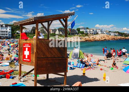 Rettungsschwimmer, die in ihrer Station sitzen, wachen an einem sonnigen Sommerferientag an der Küste von Maine über die Menge am Strand Stockfoto