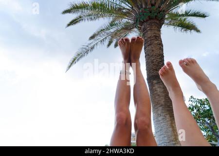 Füße in der Luft gegen Palmen und blauen Himmel Stockfoto