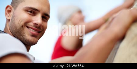 Gemeinsam überwinden sie Herausforderungen. Porträt eines jungen Paares, das gemeinsam eine Felswand klettert. Stockfoto