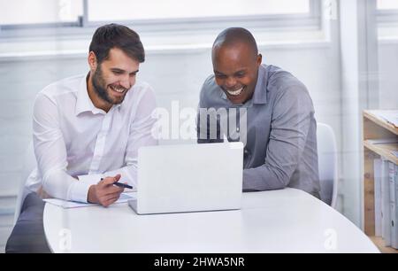 Technologie sorgt für einen reibungslosen Geschäftsablauf. Zwei Geschäftsleute, die mit einem Laptop in einem Büro sitzen, während sie ein Meeting abhalten. Stockfoto