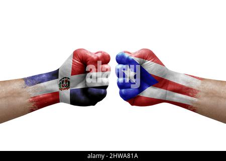 Zwei Hände schlagen sich gegenseitig auf weißem Hintergrund zu. Länderflaggen bemalten Fäuste, Konfliktkrisenkonzept zwischen der dominikanischen republik und puerto rico Stockfoto
