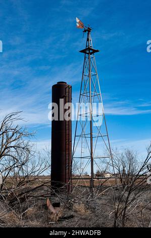 Altes Ackerland mit großem Silo und einer hohen Windmühle im ländlichen New Mexico. Stockfoto