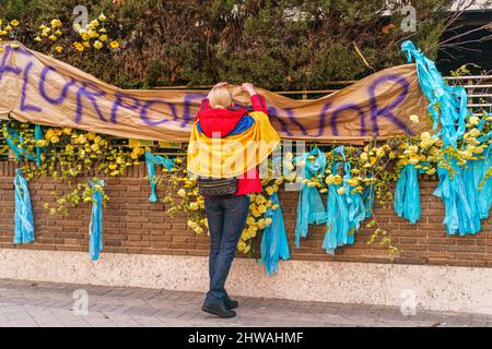 Madrid, Spanien. 03. März 2022. Ein Protestler mit einer Flagge stellt vor der russischen Botschaft während einer Kundgebung aus Protest gegen den Krieg zwischen der Ukraine und Russland ein Transparent, Dekorationen in ukrainischen Farben, blau und gelb, auf. Die Ukraine ist seit den russischen Anschlägen vom 24. Februar seit neun Tagen in einen Krieg gestürzt. Kredit: SOPA Images Limited/Alamy Live Nachrichten Stockfoto