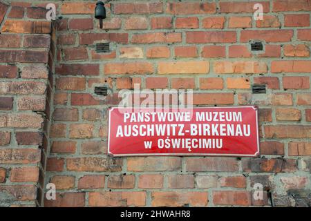 Staatliche Museumsklappe von Auschwitz-Birkenau, an einer Ziegelwand montiert Stockfoto