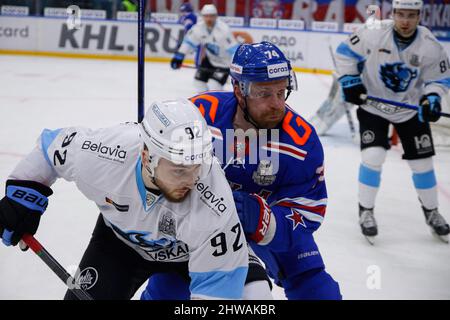 Sankt Petersburg, Russland. 04. März 2022. SKA Hockey Club Spieler, Leo Komarov (C) und Dinamo Hockey Club Spieler Roman Gorbunov (L), in Aktion während der Kontinental Hockey League, Gagarin Cup, KHL 2021/22 zwischen SKA Sankt Petersburg und Dinamo Minsk im Ice Sports Palace.(Endstand; SKA Sankt Petersburg 3:1 Dinamo Minsk) Kredit: SOPA Images Limited/Alamy Live News Stockfoto