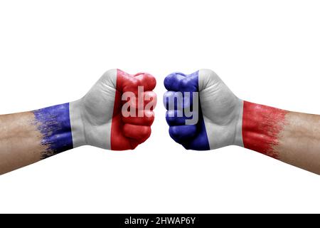 Zwei Hände schlagen sich gegenseitig auf weißem Hintergrund zu. Länderflaggen bemalten Fäuste, Konfliktkrisenkonzept zwischen frankreich und frankreich Stockfoto