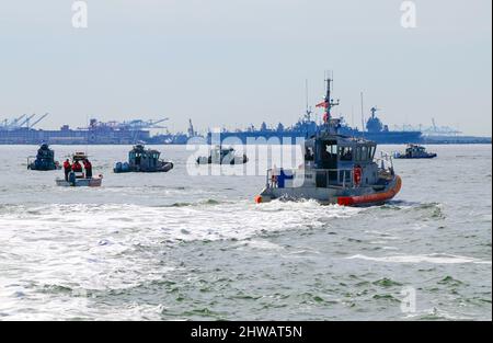 Ein 47-Fuß-Boot-Medium von der Küstenwache Portsmouth und andere teilnehmende kleine Bootsmannschaften können sich im Rahmen des regionalen Such- und Rettungsforums, das am 3. März 2022 in Hampton, Virginia, veranstaltet wird, eine Live-Action-Helikopter-Demonstration ansehen. Das SAR Forum ist eine jährliche Veranstaltung, die die regionalen Partnerschaften und die Kommunikation zwischen den Behörden weiter stärkt und die lebensrettenden Prozesse und Fähigkeiten verbessert, die von Such- und Rettungsbehörden benötigt werden. Foto der US-Küstenwache von Petty Officer, Klasse 1., Stephen Lehmann. Stockfoto