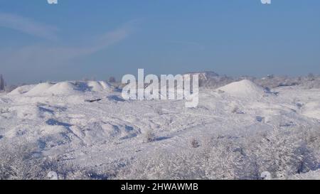 Szenischer Blick auf eine Landschaft von Donbass Abfallhaufen bedeckt mit weißem Schnee an einem frostigen Morgen Stockfoto