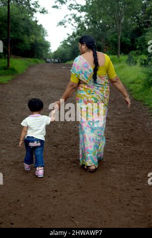 Indische Großmutter und Kind beim Spaziergang im Garten. Stockfoto