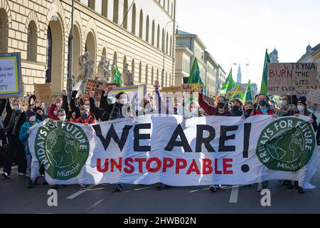 München, Deutschland. 04. März 2022. Bis zu 300 Klimaaktivisten versammelten sich am 4.. März 2022 in München, um für mehr Klimaschutz zu protestieren. Banner mit der Aufschrift: 'Wir sind unaufhaltsam!' (Foto: Alexander Pohl/Sipa USA) Quelle: SIPA USA/Alamy Live News Stockfoto