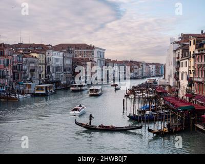 Venedig, Italien - Januar 6 2022: Das Stadtbild des Canale Grande von der Rialtobrücke mit Gondel und Vaporetto-Booten im Winter Stockfoto