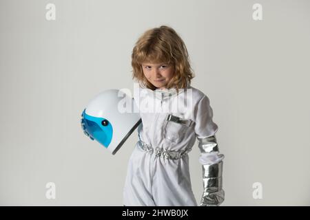 Das kleine Kind will einen Astronauten-Helm im Weltraum tragen. Speicherplatz kopieren. Innovation und Inspiration für Kinder. Stockfoto