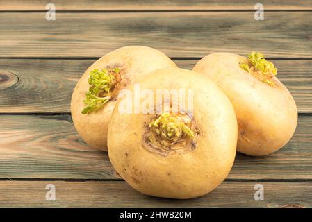 Drei reife gelbe Rüben auf einem hölzernen Hintergrund. Nahaufnahme. Stockfoto