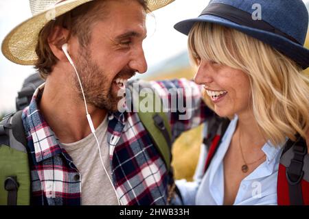 Nahaufnahme eines jungen glücklichen Paares, das verliebt ist, während er an einem schönen sonnigen Tag auf einer Wiese spazierengeht. Wandern, Natur, Beziehung, zusammen Stockfoto