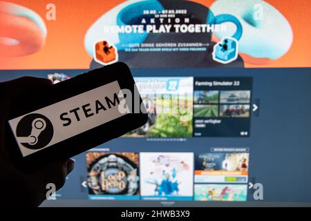 Rheinbach, Deutschland 4. März 2022, das Markenlogo der Gaming-Plattform 'Steam' auf dem Display eines Smartphones vor dem Steam Store Stockfoto