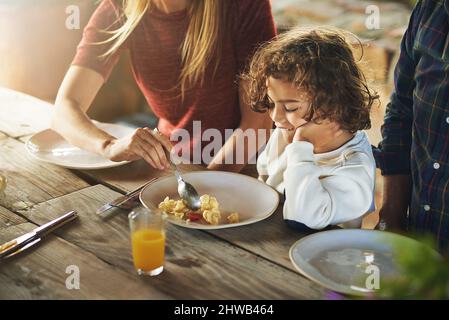 Er braucht seine Mutter, um ihn zu ernähren. Aufnahme einer Familie aus dem hohen Winkel zum gemeinsamen Mittagessen im Freien. Stockfoto