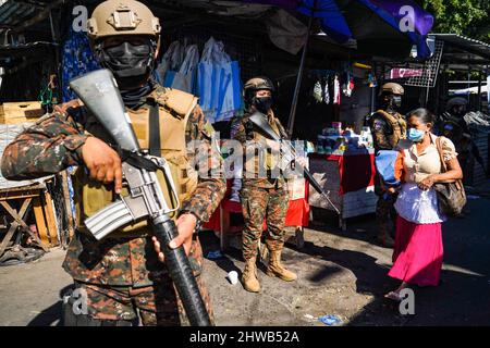 San Salvador, El Salvador. 04. März 2022. Während einer Militärpatrouille in der Innenstadt von San Salvador bewachen Soldaten einen Straßenmarkt. Seit 2000 dürfen Frauen die Reihen der salvadorianischen Streitkräfte integrieren, am 8.. März wird der Internationale Frauentag gefeiert, wobei die Öffnung traditioneller, von Männern geführte Räume für Frauen eine von vielen Forderungen ist. (Foto von Camilo Freedman/SOPA Images/Sipa USA) Quelle: SIPA USA/Alamy Live News Stockfoto