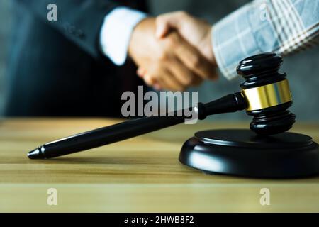 Rechtsberater oder Rechtsanwaltsassistent schütteln Hand mit dem Kunden oder Kunden nach erfolgreichem Urteil und gewinnen, Recht und Gerechtigkeit Konzept Stockfoto