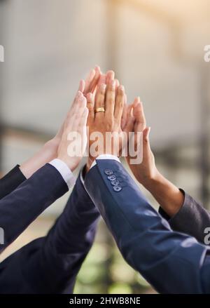 Wir haben es getan. Aufnahme einer Gruppe von Büromitarbeitern, die sich gegenseitig eine hohe fünf gaben. Stockfoto