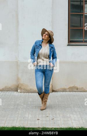 Touristenfrau, die sich umsieht und posiert, während sie im Freien spazieren geht. Stockfoto