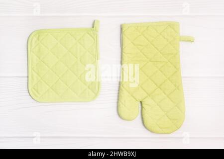 Ofenhandschuh und Topflader auf Holzhintergrund. Küchenzubehör. Flach liegend. Stockfoto