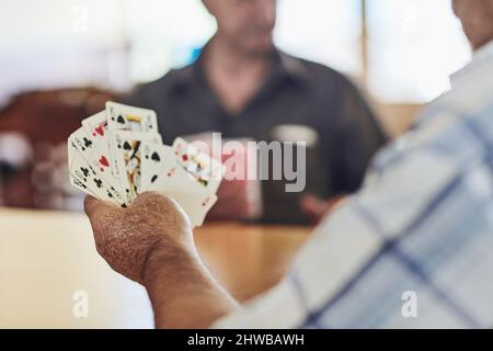 Schau dir diese Hand an. Kurzer Schuss von Senioren, die in ihrem Altersheim Poker spielen. Stockfoto