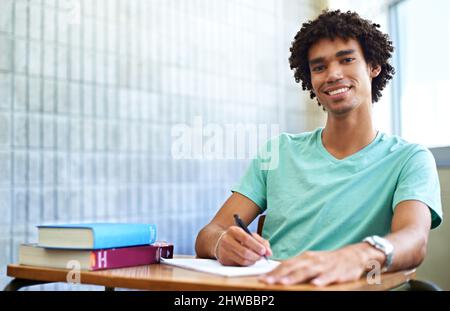 Untersuchungen kein Schweiß. Ein junger Student, der in der Klasse sitzt und lächelt vor der Kamera. Stockfoto