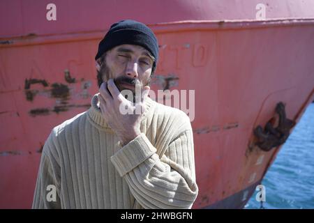 Der Mann mit dem Matrosen im Hafen Stockfoto