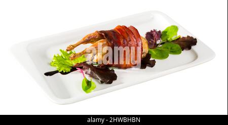 Fotografie der Platte mit gebackenen in Speck Wachtel mit Balsamico Essig. Auf weissem Hintergrund Stockfoto