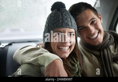 Von Liebe erwärmt. Ein junges Paar sitzt in ihrem Auto, während es regnet. Stockfoto