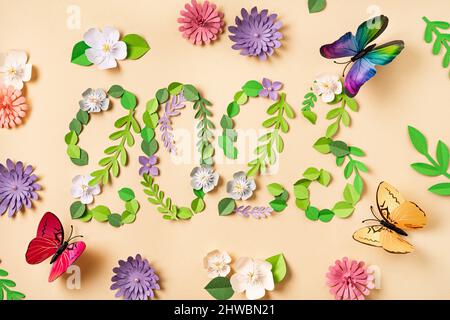 2023 Zahl aus Papierblumen und Blättern. Wunderschöne Schmetterlinge fliegen umher. Papierkunst. Floraler natürlicher Hintergrund