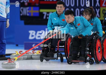 Peking, China. 5. März 2022. Zhang Mingliang (Front) aus China tritt am 5. März 2022 bei den Paralympischen Winterspielen 2022 im Nationalen Wassersportzentrum in Peking, der Hauptstadt Chinas, bei der Rollstuhlcurling Round Robin Match zwischen China und Kanada in Peking an. Quelle: Du Xiaoyi/Xinhua/Alamy Live News Stockfoto