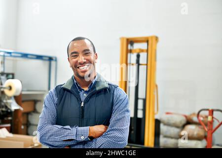 Meine Fabrikhalle ist eine gut geölte Maschine. Porträt eines lächelnden Fabrikarbeiters. Stockfoto