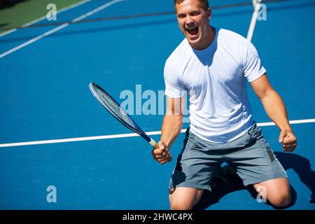 Gewinnen. Aufnahme eines Mannes, der den Sieg in einem Tennismatch feiert. Stockfoto