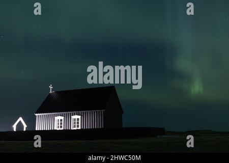 Nordlichter über einer schwarzen Kirche in Island Stockfoto