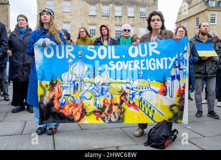 Bath, Großbritannien. 5.. März 2022. Demonstranten halten ein Banner zur Unterstützung der Ukraine hoch, während sie Reden vor der Abtei von Bath während einer Demonstration gegen die russische Invasion in der Ukraine hören. Die Demonstration wurde organisiert, um den Menschen vor Ort zu ermöglichen, ihre Solidarität mit der Ukraine im Krieg zwischen Russland und der Ukraine zu zeigen und Putins Aktionen zu verurteilen. Quelle: Lynchpics/Alamy Live News Stockfoto