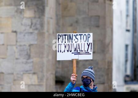 Bath, Großbritannien. 5.. März 2022. Ein Protestler hält das Kriegsplakard auf, während er Reden vor der Abtei von Bath während einer Demonstration gegen die russische Invasion in der Ukraine hört. Die Demonstration wurde organisiert, um den Menschen vor Ort zu ermöglichen, ihre Solidarität mit der Ukraine im Krieg zwischen Russland und der Ukraine zu zeigen und Putins Aktionen zu verurteilen. Quelle: Lynchpics/Alamy Live News Stockfoto