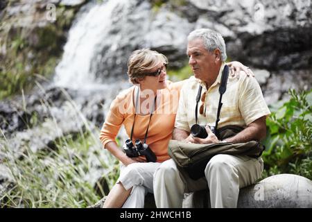 Eine Verschnaufpause Ein älteres Paar, das eine Pause einnahm, während es gemeinsam im Wald spazierenging. Stockfoto