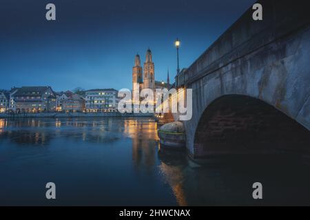 Grossmünster Kirche und Münsterbruckebrücke bei Nacht - Zürich, Schweiz Stockfoto