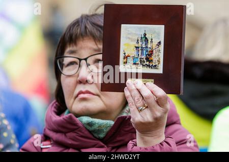 Bath, Großbritannien. 5.. März 2022. Eine Frau vor der Abtei von Bath hält eine gerahmte Zeichnung von Kiew hoch, während sie Reden während einer Demonstration gegen den russischen Einmarsch in die Ukraine hört. Die Demonstration wurde organisiert, um den Menschen vor Ort zu ermöglichen, ihre Solidarität mit der Ukraine im Krieg zwischen Russland und der Ukraine zu zeigen und Putins Aktionen zu verurteilen. Quelle: Lynchpics/Alamy Live News Stockfoto