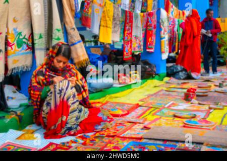 Verschwommenes Bild von Kalkutta, Westbengalen, Indien. Junge bengalische Künstlerin malt Paptachitra oder Patachitra - traditionelles, auf Stoff basierendes Scroll Paintin Stockfoto