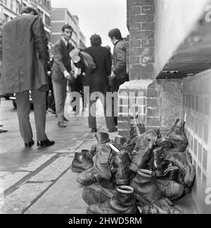 In der Farringdon Road, London, treffen sich Skinheads.zwanzig bis dreißig Jugendliche wurden entlang der Farringdon Road verfolgt, nachdem sie einen verdrosselten Zug und einen angeblichen Angriff auf einen Mann verübt hatten. Die Häupter wurden angehalten und mussten ihre Stiefel ausziehen, während die Polizei sie an einer Wand anstellte und sie durchsuchte. Das Bild zeigt: Ein Haufen Stiefel auf dem Boden, der auf Wunsch der Polizei während der Ermittlungen entfernt wurde. 4.. April 1970. Stockfoto