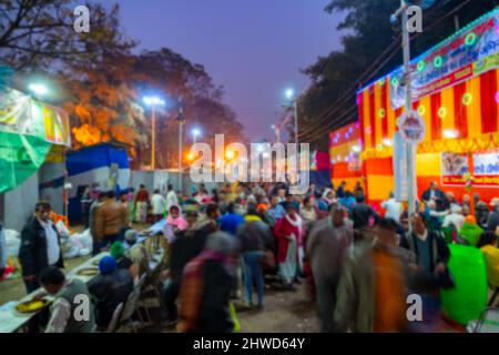 Verschwommenes Bild von Kalkutta, Westbengalen, Indien. Eifrige Anhänger, die am Abend im Gangasagar-Durchgangslager spazieren gehen, um hinduistische Sadhus in ihren Lagern zu besuchen, in Bab Stockfoto