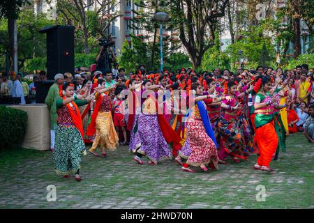 Kalkutta, Indien - 21.. März 2019: Tänzerinnen, bekleidet mit farbenfrohen Sari (traditionelles indisches Kleid) und Palashblumen (Butea monosperma). Stockfoto