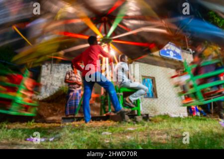 Verschwommenes Bild von Howrah, Westbengalen, Indien. Person beim Reiten Kinder auf Nagordola - eine traditionelle Vergnügungsfahrt auf bengali Neujahr. Stockfoto